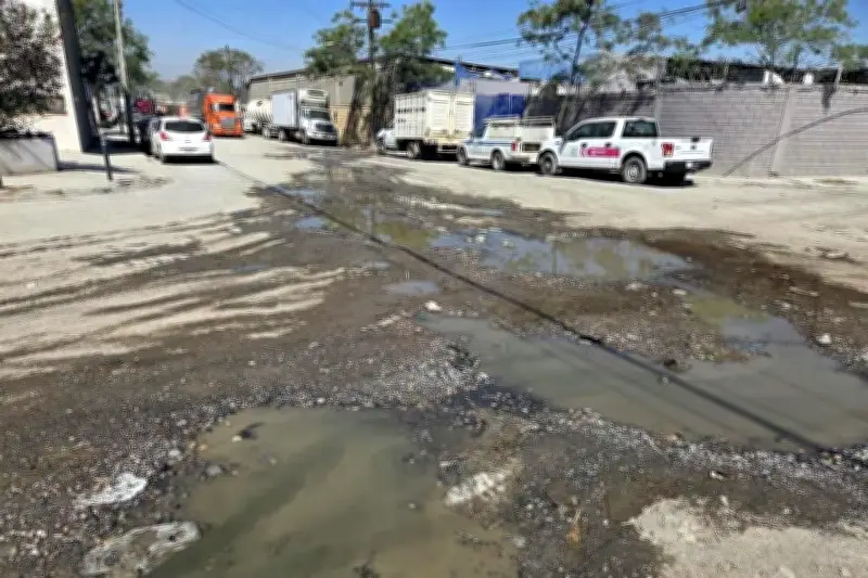 Agobian fuga de agua y baches a la principal avenida de carga en la capital