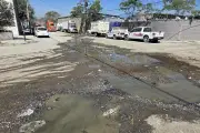 Agobian fuga de agua y baches a la principal avenida de carga en la capital